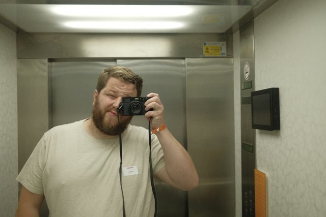 a photograph of a man taking a selfie in a elevator