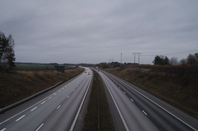 a photograph of a highway with cars driving down the road
