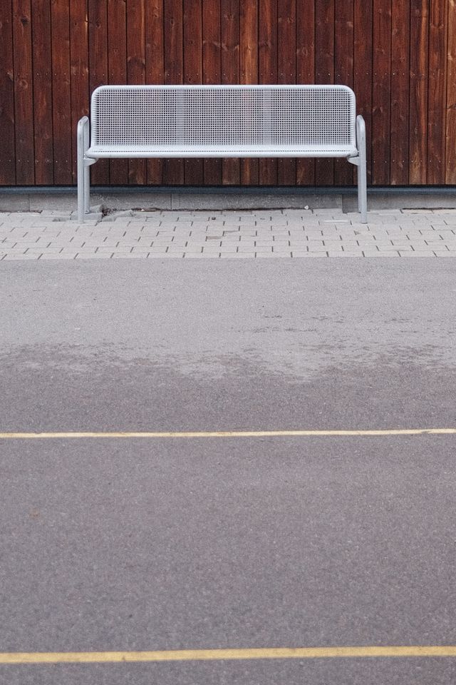a photograph of a white bench with a white bench and a wooden fence