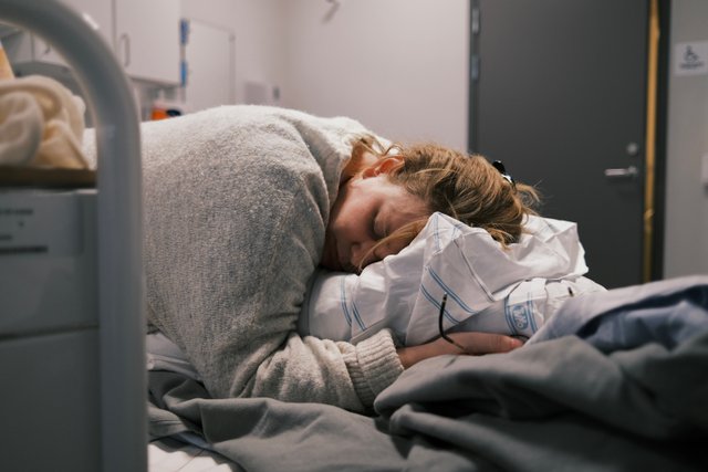 a photograph of a woman is sleeping in a hospital bed