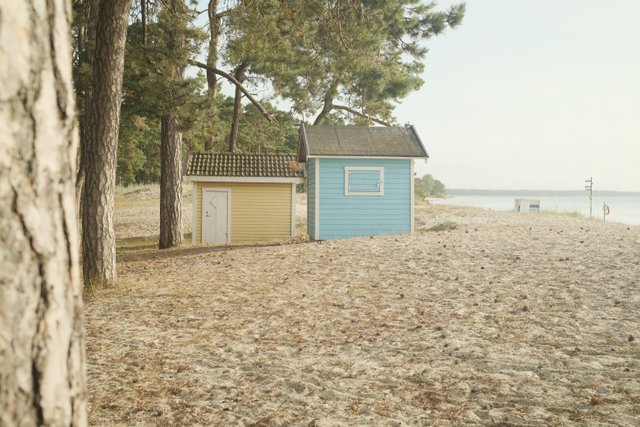 a photograph of a beach hut with a blue and yellow beach hut with a blue and yellow hut